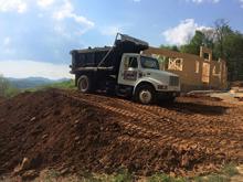 Using a large Dump Truck to Haul Dirt excavated from the Houser Job.